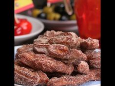 there are some sugar coated doughnuts on the plate with cherries in the background