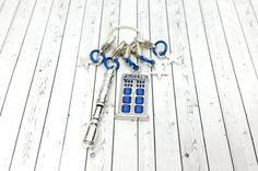 a blue and white keychain with keys attached to it on a wooden floor