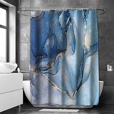 a bathroom with a shower curtain that has blue and gold marble design on the outside