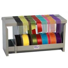 multicolored ribbons are stacked on top of each other in a display case for sale