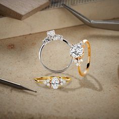 three different types of engagement rings on a table next to scissors and other jewelry items