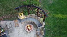 an aerial view of a fire pit with chairs around it