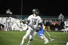 a lacrosse player is running with the ball