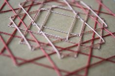 some red and white lines on a piece of paper that has been stitched together