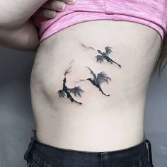 a woman's stomach with three birds flying in the sky on her side tattoo