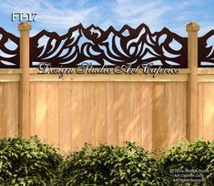 a wooden fence with decorative iron work on the top and bottom panels, along with bushes