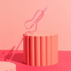 a pair of scissors sitting on top of a pink table next to a round object