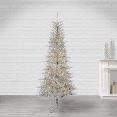 a white christmas tree in front of a fireplace