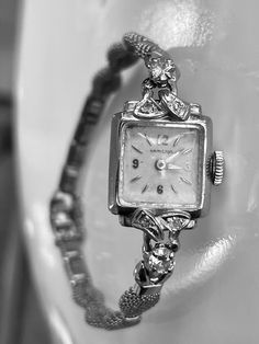 Vintage Art Deco 14k White Gold Hamilton Watch with genuine diamond accents. The watch is 14k gold with diamonds.  There are two larger round brilliant diamonds that measure 3.5mm in diameter and four smaller diamonds that are 1.5mm in diameter.  Total carat weight of the diamonds is approximately 0.42 calculated by measurements.  They are round brilliant cut and nice quality in the range of SI1 clarity and H/I color.   The watch face and bezel are solid 14k white gold and stamped.  The band is Classic Diamond White Round Diamond Watch, Classic Diamond Jewelry With Brilliant Cut, Classic Diamond Accented Watch For Anniversary, Classic Diamond White Watch For Anniversary, Formal Yellow Gold Diamond Watch With Diamond Accents, Yellow Gold Diamond Watch With Brilliant Cut For Anniversary, Formal Yellow Gold Diamond Watch With Accents, Classic Jewelry And Watches With Diamond Accents For Anniversary, Yellow Gold Watches With Diamond Accents For Gift