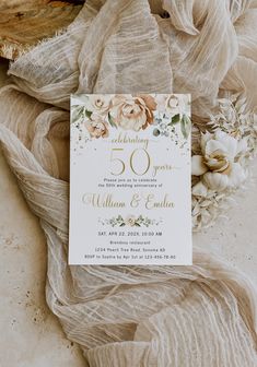 the wedding stationery is laid out on top of sheer fabric and has an elegant floral design