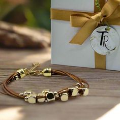 Get ready to elevate your wrist game with this multi-strand leather bracelet. Featuring gold-plated floating beads and a lobster clasp closure, this timeless piece is the perfect way to add a touch of sophistication to any outfit. Length: 6.5" + 1.5" extender chain - for an adjustable fit Lobster clasp closure - for a secure fit 6 strands of brown leather - for the perfect boho vibe 18K PVD Gold plated stainless steel - long lasting plating and hypoallergenic Handmade in China - to bring you the Gold Multi-strand Wrap Bracelet For Gift, Gold Multi-strand Beaded Bracelet As Gift, Adjustable Double Strand Gold-tone Jewelry, Adjustable Gold Leather Bracelet Chic Style, Adjustable Gold Leather Chic Bracelet, Gold Adjustable Double Strand Beaded Bracelets, Chic Leather Bracelet Jewelry, Adjustable Gold Leather Bracelet, Adjustable Leather Jewelry With Adjustable Chain