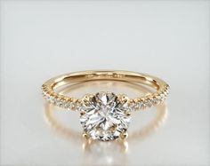 a yellow gold engagement ring with diamonds on the side