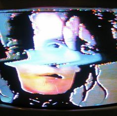 an old television with the image of a woman wearing a hat on it's face