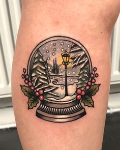 a snow globe tattoo on the leg