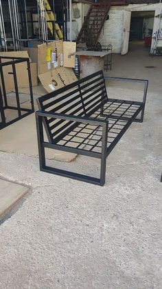 two metal benches sitting on top of a cement floor next to boxes and other items