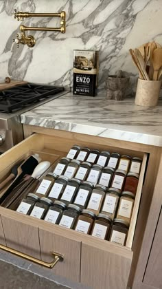 an open drawer in a kitchen filled with spices