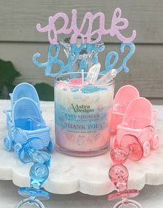 a candle that is sitting next to some baby carriage decorations on a cake platter