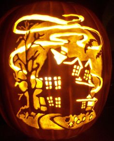 a carved pumpkin with an image of a house and trees in the night sky on it