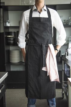 a man standing in a kitchen wearing an apron