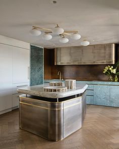 a kitchen with marble counter tops and gold trimmings on the walls, along with wooden flooring