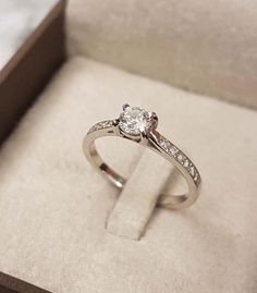 an engagement ring in a box with the wedding band on it's side and diamond set at the top