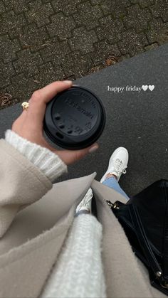 a person holding a coffee cup in their hand and the words happy friday written on it