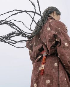 a woman with dreadlocks walking down the street