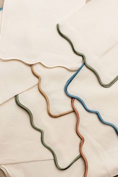 four napkins with different colored wavy lines on them