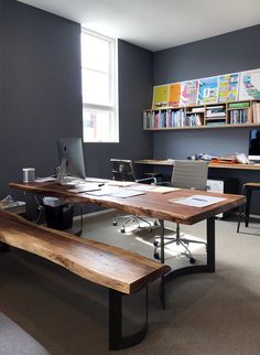 an office with desks, computers and bookshelves