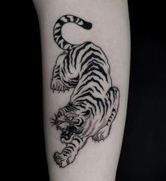 a black and white tiger tattoo on the leg