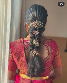 a woman with long hair in a pink sari and gold jewelry on her head