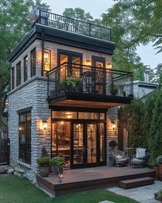 a house that has some lights on in the windows and stairs to the second floor