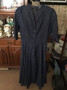 "Vintage 1950's dark Blue sheer Plisse fabric dress. Buttons down the front with Black buttons that have a large Rhinestone in the center. No makers tag. The fabric has no stretch and there is no seam allowances. Has shoulder pads. Since the dress is a SHEER fabric, you may want to wear a full slip underneath. *MORE INFORMATION BELOW* CONDITION: Is missing a belt. One button is missing the Rhinestone. There is a snap at the waist and is missing one side. MEASURES: Bust-36\" Waist-26\" Hips-54\" 1950s Style Formal Dress With Button Closure, Vintage Blue Vintage Style Formal Dress, Vintage Blue Formal Vintage Dress, Vintage Formal Dresses With Button Closure, 1950s Style Formal Dresses With Buttons, Vintage Evening Dress With Covered Buttons, Vintage Blue Formal Dress, Vintage Blue Button-up Dress, Vintage Evening Dresses With Buttons