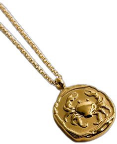 a gold pendant with a crab on it