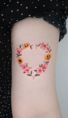 a woman's thigh with flowers in the shape of a heart