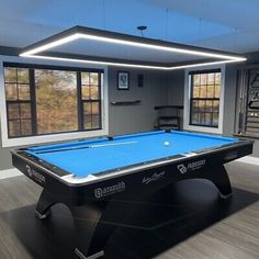 a pool table in an empty room with windows