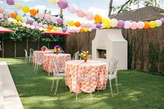 an outdoor dining area with tables and chairs covered in orange checkered tablecloths