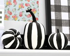 black and white striped pumpkins sitting on a mantle