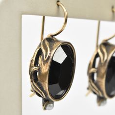 Faceted black glass stone Bronze components Pearl accents Locking french wire earring Earrings measure 1" long Made by Extasia Designer Jewelry. Goldmakers Jewelry Mission Statement Goldmakers Jewelry creates and curates a comprehensive selection of artfully designed hand-crafted jewelry. We aspire to offer the jewelry enthusiast access to affordable classics as well as fresh innovative designs. Bronze Metal Jewelry For Evening, Onyx Jewelry With Matching Earrings For Evening, Handmade Black Brass Earrings, Nickel-free Black Brass Earrings, Onyx Earrings For Evening, Victorian Metal Jewelry With Matching Earrings, Vintage Black Metal Earrings, Black Vintage Metal Earrings, Elegant Handmade Black Clip-on Earrings