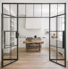 an open kitchen with glass doors leading into the dining room