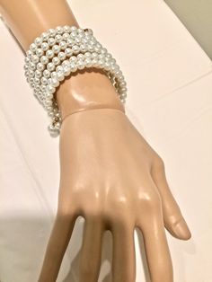 "Stunning, classy, and elegant piece of jewelry. Made of glass pearls beaded on gold color memory wire. Can be adjusted to any wrist size. It can be combined with many other piece from my \"Pearl Madness\" collection also offered in this shop (see the other pearl items). 6 - 7 wire strings." White Pearl Stretch Bracelet For Party, Elegant Pearl White Stretch Pearl Bracelet, Elegant Pearl White Pearl Stretch Bracelet, Elegant Pearl Stretch Bracelet For Party, Elegant Beaded Pearl Stretch Bracelet, Elegant Pearl Beaded Stretch Bracelet, White Adjustable Beaded Bracelets For Formal Occasions, Elegant Pearl White Stretch Bracelet, Elegant White Pearl Stretch Bracelet