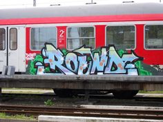 a red and white train with graffiti on it's side