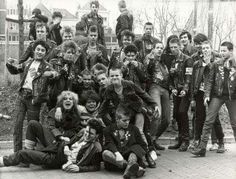 an old black and white photo of young children posing for a group shot in the street