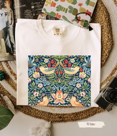 COMFORT COLORS T-Shirt Add a touch of iconic design to your wardrobe with this T-shirt featuring William Morris's beloved Strawberry Thief pattern (1883). This intricate and timeless design, inspired by nature, brings the beauty of classic British arts and crafts to your everyday style. Perfect for those who appreciate heritage patterns and elegant, vintage-inspired fashion. T-SHIRT DETAILS We use COMFORT COLORS for our T-shirts: High Quality, SUPER soft and SUPER comfy. ✿ Garment dyed for that Floral Print Cotton T-shirt, Patterned Cotton T-shirt With Graphic Print, Patterned Cotton T-shirt With Relaxed Fit, Multicolor Screen Print Cotton Top, Patterned Floral Print Cotton T-shirt, Spring Cottagecore Shirt With Graphic Print, Cottagecore Cotton Printed T-shirt, Cottagecore T-shirt With Plant Print For Spring, Cotton T-shirt With Strawberry Print