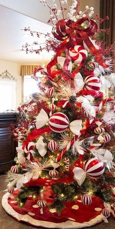 a christmas tree decorated with red and white ornaments, bows, and candy canes