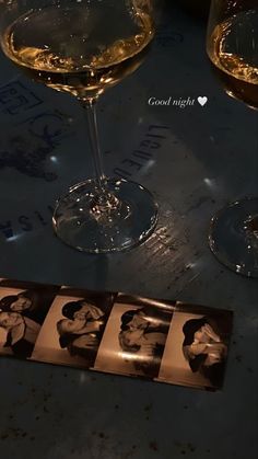 three wine glasses are sitting on a table next to an old photo with the same person in it