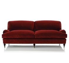 a red couch sitting on top of a white floor