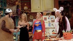 the cast of friends dressed up as supergirls in a kitchen with costumes on