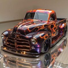 an old truck with flames painted on it