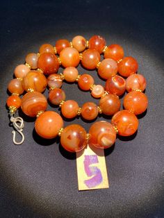 The beautiful orange color carnelian beads necklace from Himalaya Nepal This beads were used in prayer malas and used as jewelry and amulets in ancient times very smooth and shinny surface of this beads because of passage of time and usage of this beads in prayers mala and in necklace The age of this beads are more than 1000 years small size gold color brass beads are used as spacers in the necklace we provide fast and free shipping service to our customers by which can get the items by maximum Antique Orange Beaded Jewelry, Antique Orange Jewelry With Round Beads, Orange Carnelian Necklace In Spiritual Style, Traditional Orange Carnelian Beaded Necklace, Hand-strung Orange Carnelian Beaded Necklaces, Carnelian Orange Amulet Necklace, Hand-strung Orange Carnelian Necklaces, Round Orange Beads With Spiritual Style, Orange Agate Beads For Jewelry Making